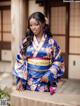 A woman in a blue and pink kimono posing for a picture.