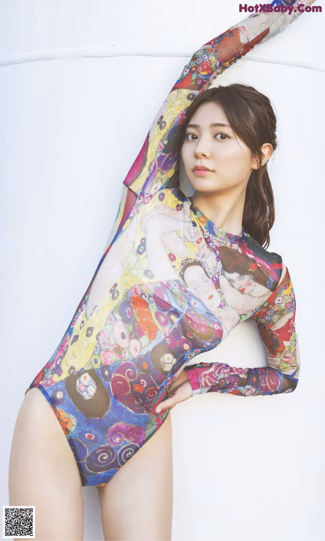 A woman in a colorful bodysuit posing for a picture.