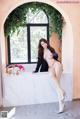 A woman in a black jacket and red panties posing in a bathtub.