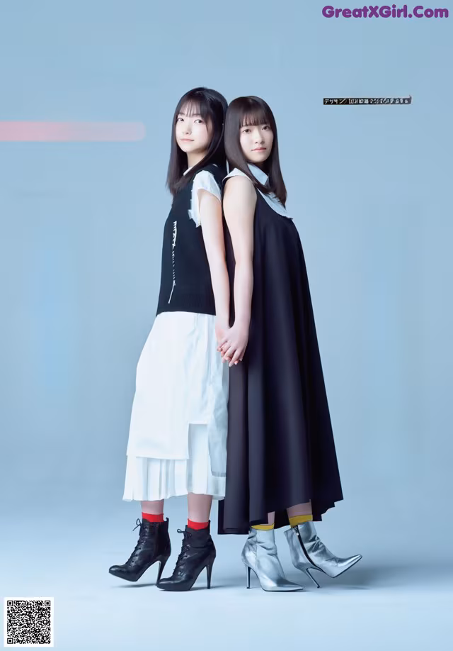 A couple of women standing next to each other on a blue background.
