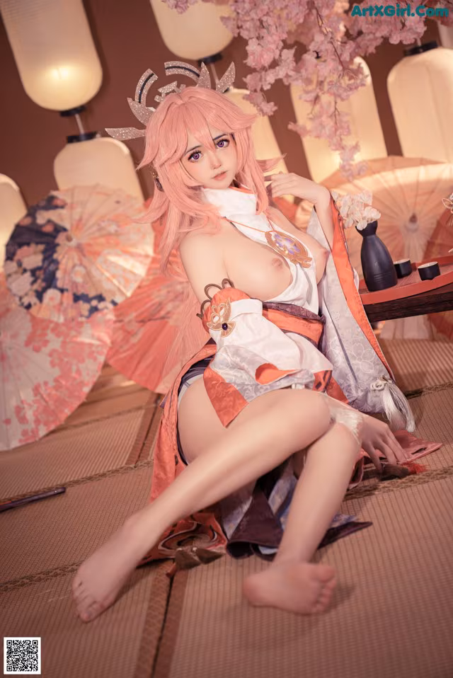 A woman in a kimono sitting on the floor with an umbrella.