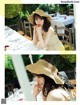 A woman sitting at a table wearing a straw hat.