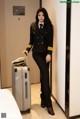 A woman in a pilot's uniform with a suitcase.