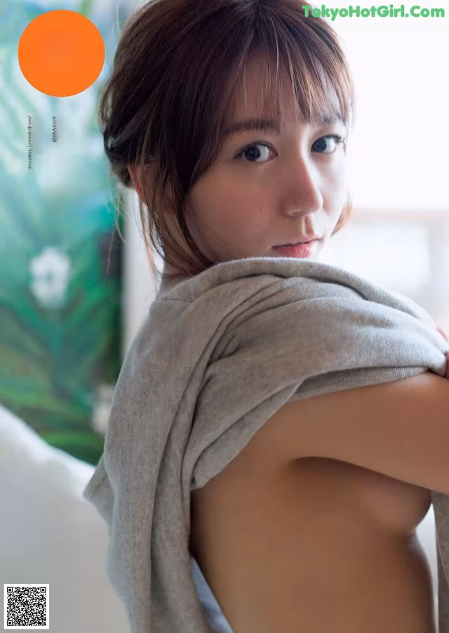 A woman wrapped in a towel is posing for a magazine cover.