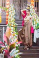 A woman in a traditional thai dress posing for a picture.