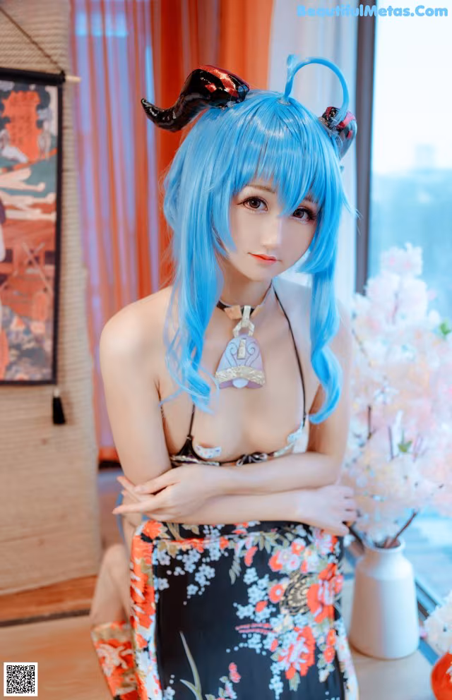 A woman with blue hair wearing a kimono sitting on a table.