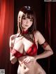 A woman in a red lingerie posing for the camera.
