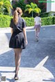 Two young women walking down a sidewalk in front of a building.