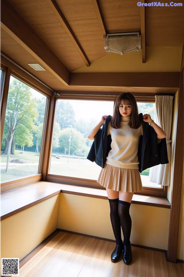 A woman standing in front of a window in a room.