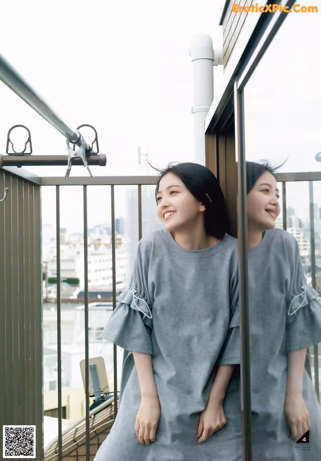 A couple of women standing next to each other on a balcony.
