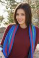 A woman wearing a red shirt and a blue and red scarf.