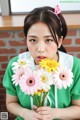 A woman holding a bunch of flowers in her hands.